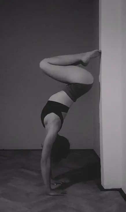 A woman doing a handstand against a wall